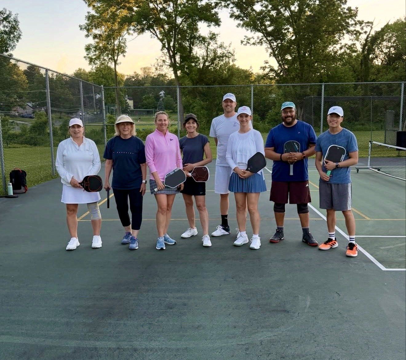 An evening adult pickleball clinic group at a Universal Rackets program